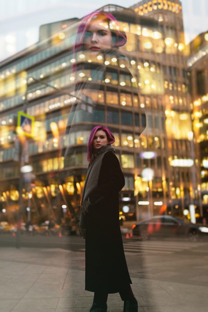 woman in black coat standing on street during night time